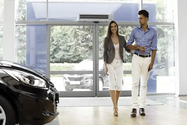 Young Couple Came into the Car Showroom. Auto Salon office scenting
