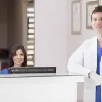 Doctor and receptionist at clean clinic front desk – representing welcoming environment through doctor office scenting