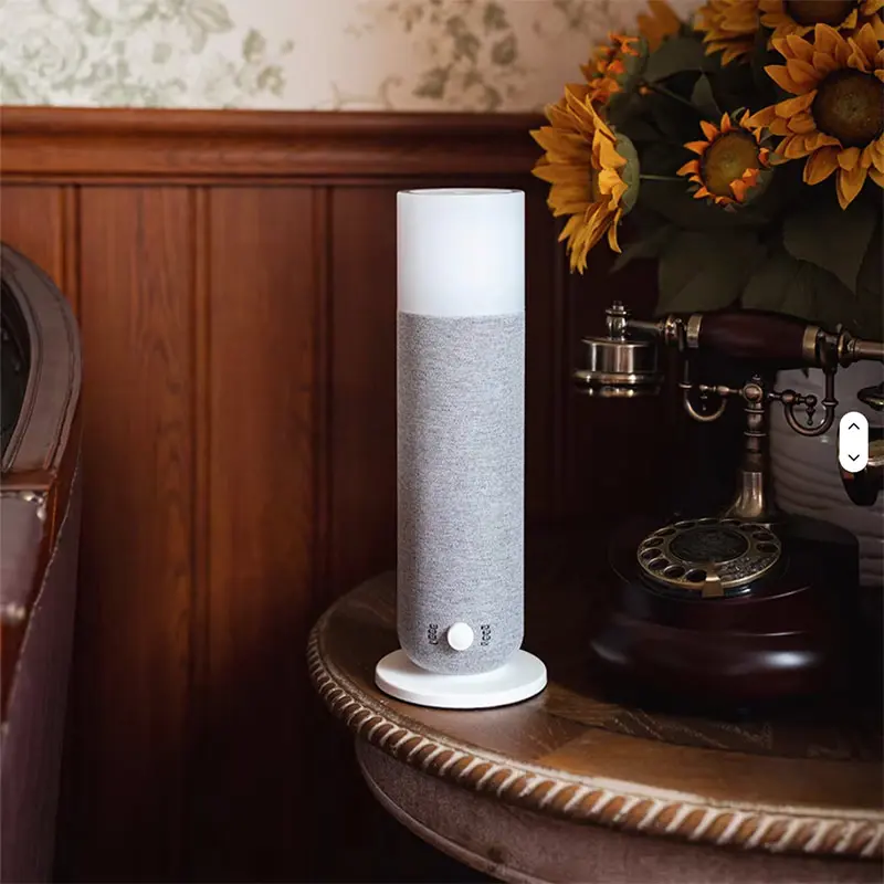 Grey fabric mini tower scent diffuser displayed on wooden side table